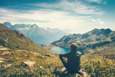 A traveler takes in the views at the top of a ridge.